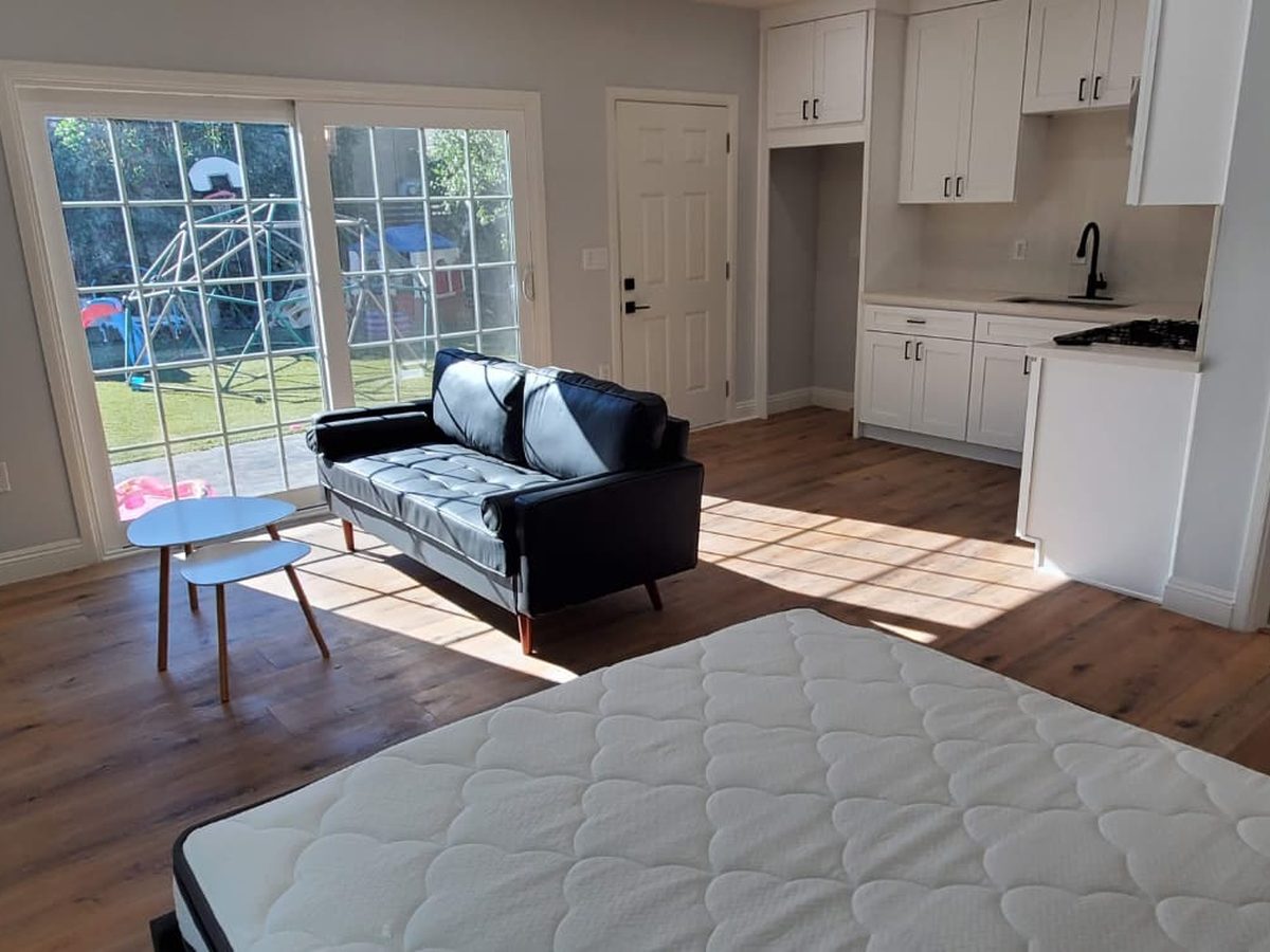 Inside a KRN ADU: living area with sliding doors to the backyard and its own kitchenette